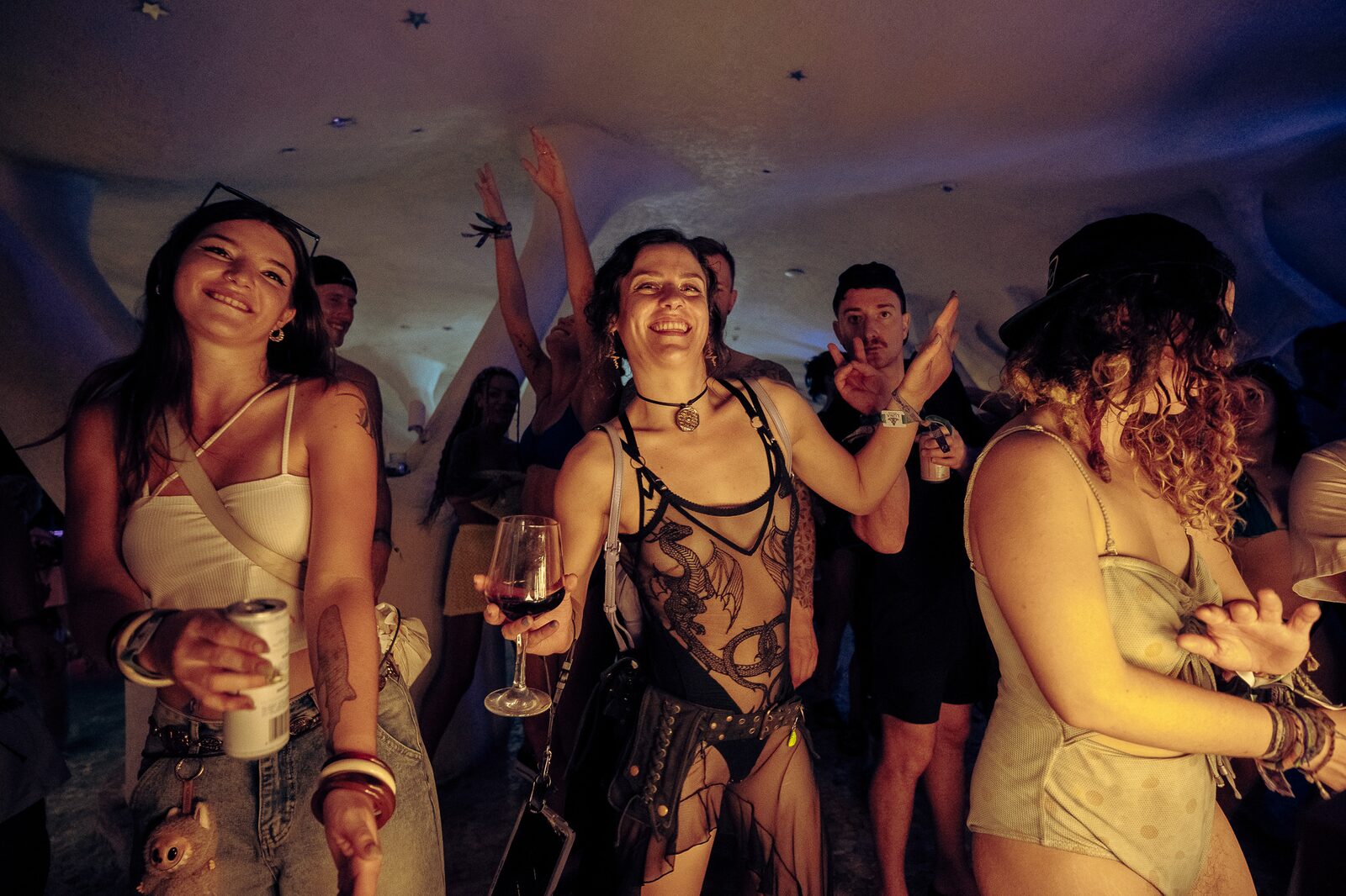 Festival-goers in an illuminated tent venue at LOCUS Bali 2025